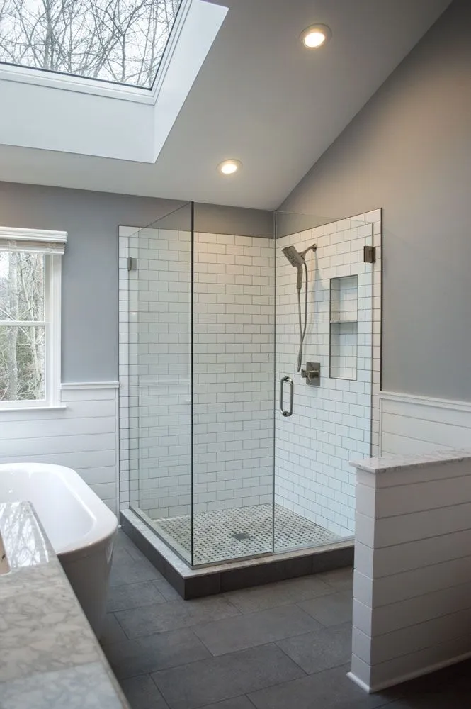 Frameless glass corner shower with white subway tile and skylight, Craftworks Construction, Fairfield County CT
